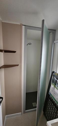une porte en verre menant à une pièce avec un miroir dans l'établissement Mobil Home P171 Le Castellas, à Sète