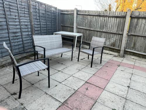 a patio with two chairs and a table and a fence at Large triple room in Canada Water London in London
