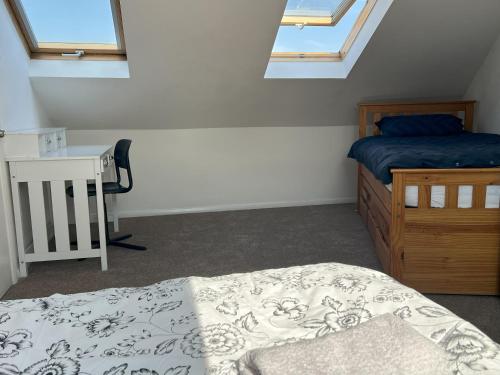 a bedroom with a bed and a desk and windows at Large triple room in Canada Water London in London