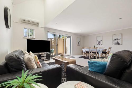 a living room with two leather couches and a television at 62CapeView Geographe bay in Broadwater