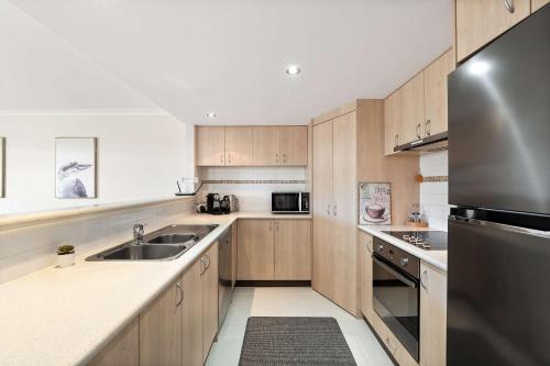 a kitchen with wooden cabinets and a stainless steel refrigerator at 62CapeView Geographe bay in Broadwater
