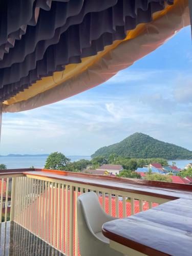 a balcony with a table and a view of a mountain at Ripples Guesthouse and Sky Bar in Koh Rong Sanloem