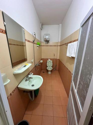 a bathroom with a toilet and a sink and a mirror at NHÀ NGHỈ Thanh Mai in Bản Có