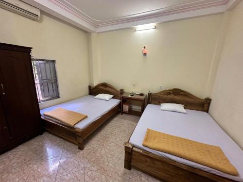 a bedroom with two beds and a sink in it at NHÀ NGHỈ Thanh Mai in Bản Có