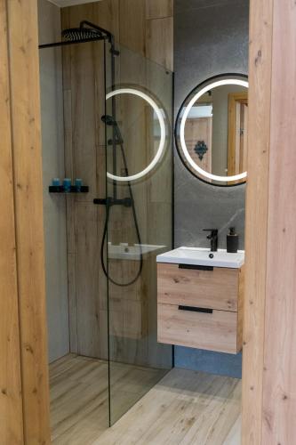 a bathroom with a shower and a sink and a mirror at Apartament JOA in Zakopane
