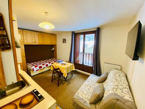 un salon avec un canapé et une table dans l'établissement Mountain-style studio, Lake, Skiing, à Allos