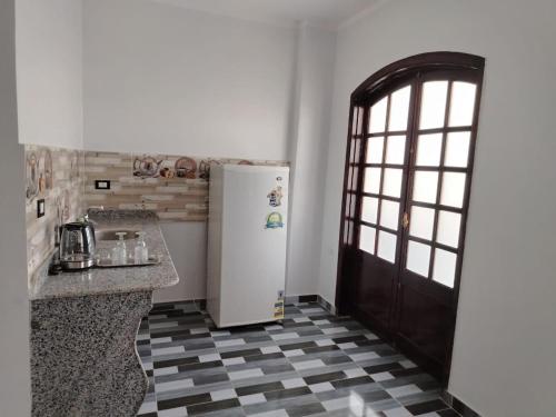 a kitchen with a refrigerator and a checkered floor at Mena Palace Nile View in Luxor