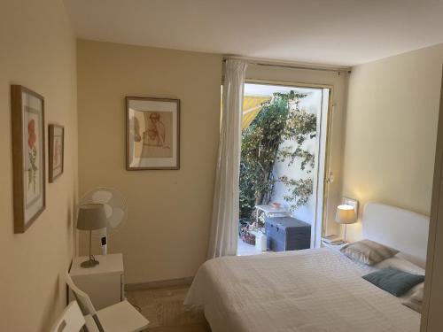 une chambre avec un lit et une porte coulissante en verre dans l'établissement Les Oliviers 3, Domaine de Pierre Longue, à Cannes