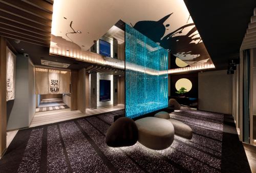 a living room with a blue glass wall and a table at HOTEL 翠 sui -TIMELESS GARDEN- in Koshido