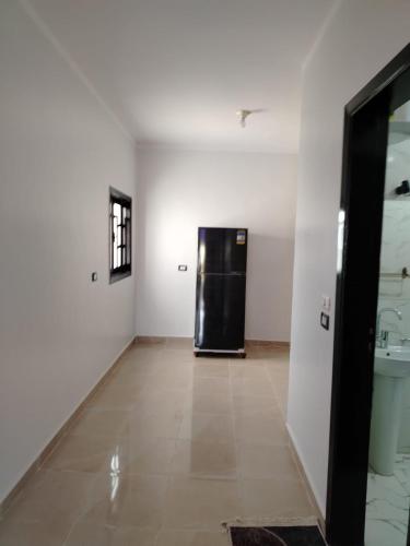 a room with a black refrigerator in a white room at Mena Palace Nile View in Luxor