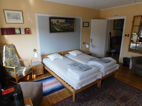 a small bedroom with a bed and a chair at Vandrarhem Solgården in Blackstad