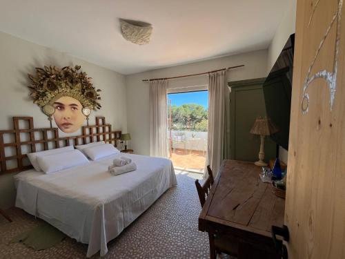 a bedroom with a bed with a head on the wall at Boutique Hostal La Curandera de Salinas in Ibiza Town
