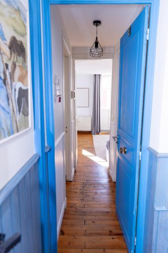 - un couloir avec des portes bleues et du parquet dans l'établissement Villa Erdian, à Saint-Jean-de-Luz