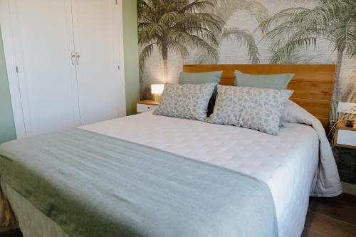a bedroom with a large white bed with pillows at Apartamento The River in El Puerto de Santa María
