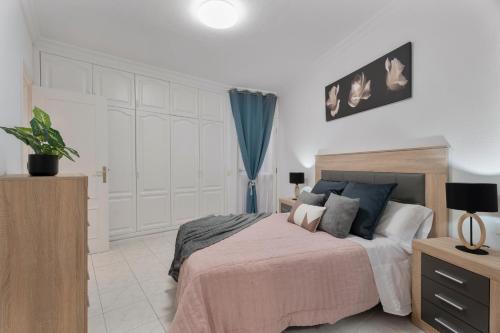 a bedroom with a large bed and a blue curtain at Apartamento Bonjour in Candelaria