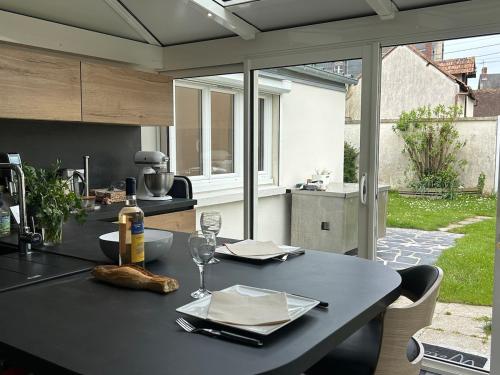 - une table noire avec une bouteille de vin dans l'établissement Maison 3 chambres hyper centre, à Cabourg