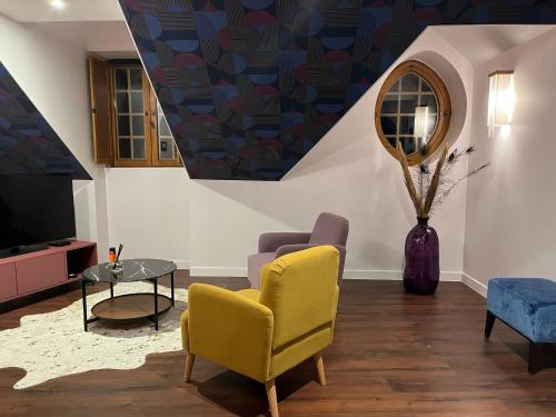 a living room with a yellow chair and a tv at La Promenade in Beaupréau