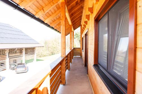a porch of a wooden house with windows at Adventure Farm in Štore