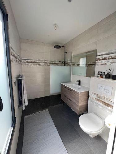 une salle de bain avec des toilettes blanches et un lavabo dans l'établissement Villa Marcheprime, à Marcheprime