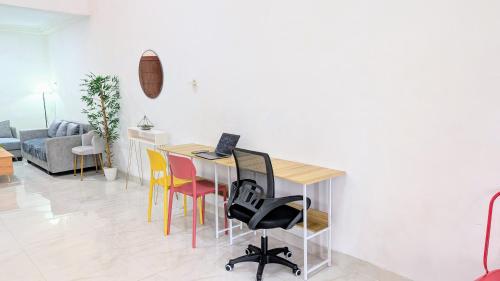 a dining room with a table with a laptop on it at Homey Guesthouse Sukomanunggal Syariah in Surabaya