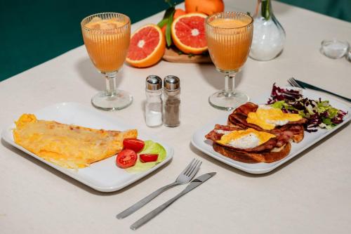 a table with two plates of breakfast food and drinks at Pensiune Restaurant Căprioara Toplița in Topliţa