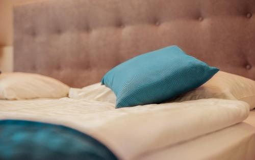 a bed with a blue pillow on top of it at Belvedere Resort Hotels in Izola