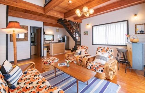 a living room with couches and a table at FLEX BEACH HOUSE in Gushiken