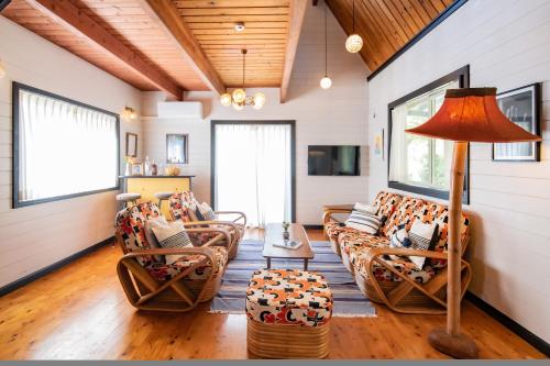 a living room with couches and a lamp at FLEX BEACH HOUSE in Gushiken
