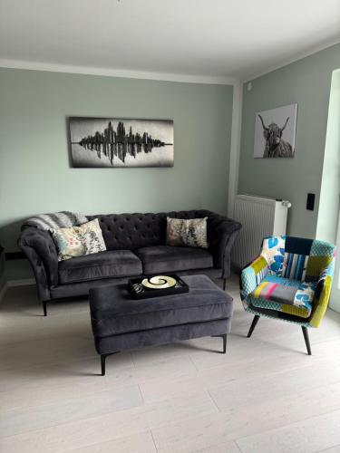 a living room with a couch and a chair at LIVA LIVING, Apartments mit Berg- und Seeblick, große Terrassen in Sankt Gilgen