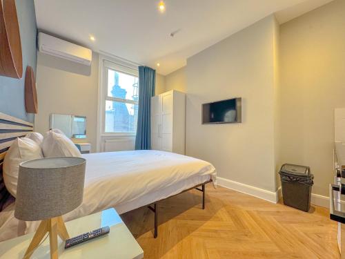 a small bedroom with a bed and a window at Earls Court Residences in London