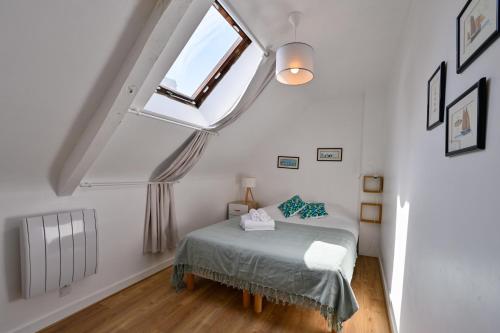 une chambre avec un lit et une fenêtre dans l'établissement Longère Kerinis - Maison avec grand jardin, à Locmariaquer