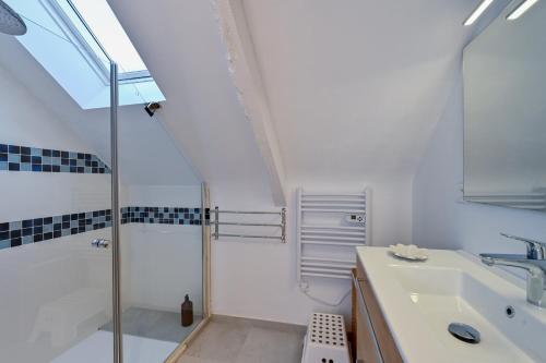 une salle de bain blanche avec une douche et un lavabo dans l'établissement Longère Kerinis - Maison avec grand jardin, à Locmariaquer