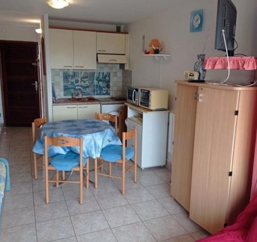 une cuisine avec une table et des chaises dans une cuisine dans l'établissement Paisible à 100m de la plage du Môle, au Cap d'Agde