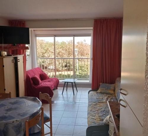 un salon avec un canapé et une table dans l'établissement Paisible à 100m de la plage du Môle, au Cap d'Agde