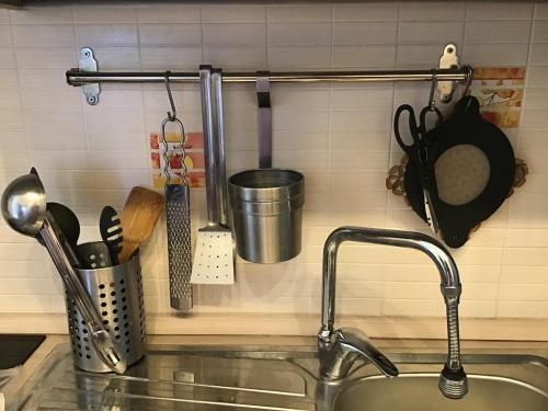 a kitchen counter with a sink and some utensils at Paravis mio - Cozy Apt by the Main Square in Piano di Sorrento