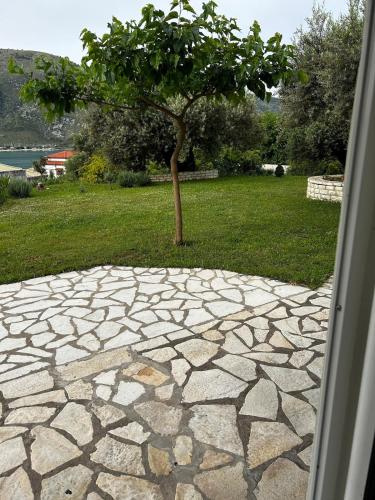 a stone walk way with a tree in the background at Marina apartment in Plataria