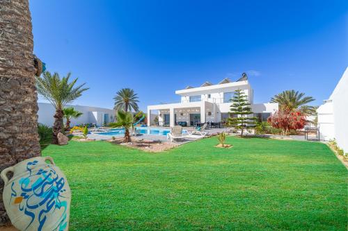 Villa mit Rasen und Pool in der Unterkunft Dar Meryem Villa piscine sans vis-à-vis Djerba in Midoun