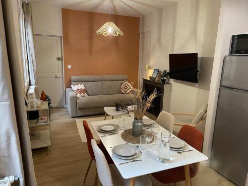 a living room with a white table and chairs at Logement cosy au cœur de Nevers in Nevers