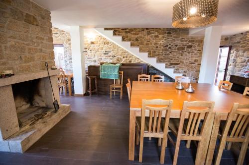 ein Esszimmer mit Tisch und Kamin in der Unterkunft Casa Mirandês Rural in Miranda do Douro
