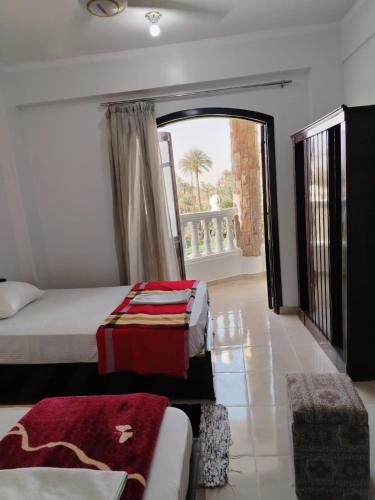 a bedroom with a bed and a large window at Mena Palace Nile View in Luxor