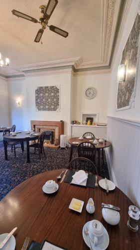 Un comedor con mesas y sillas y una chimenea. en The Cavendish, en Scarborough