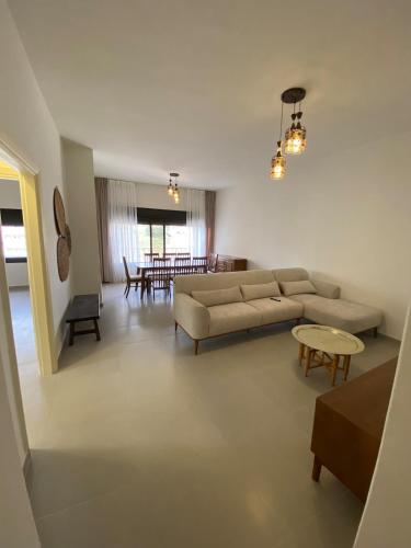 a living room with a couch and a table at Modern 2BR in Trendy Jabal AlWebdeh with View in Amman