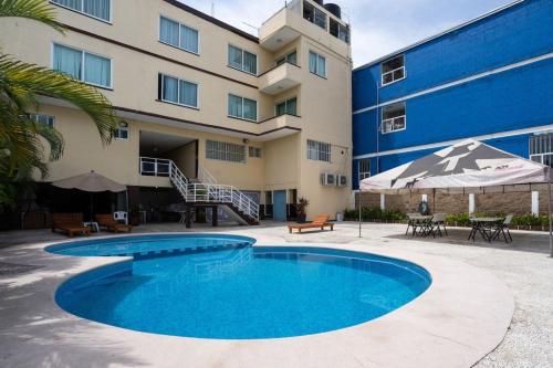 a swimming pool in front of a building at Capital O Hotel Los Caracoles, Acapulco in Acapulco
