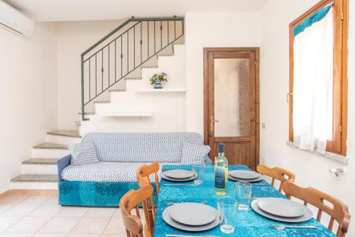a dining room with a table and a couch at Sardegnaest vista mare piscina spa in Budoni