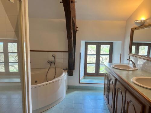 une salle de bain avec deux lavabos et une baignoire dans l'établissement Maison 8 couchages piscine privée, à Roquecor