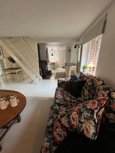 a living room with a couch and a staircase at Hyggeligt hus in Lilla Stockhult