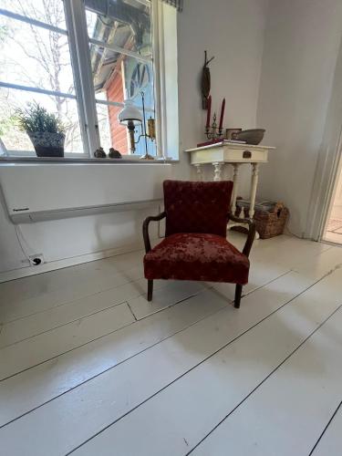 a chair sitting in a room with a window at Hyggeligt hus in Lilla Stockhult