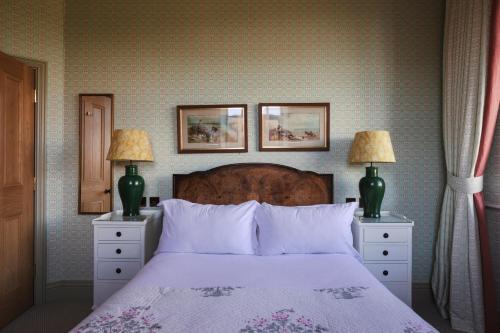 a bedroom with a bed with two lamps and two dressers at Wesleyan Bolton Abbey Estate in Appletreewick