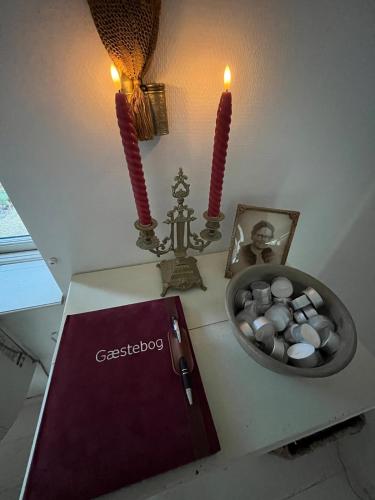 a table with two candles and a bowl of pills at Hyggeligt hus in Lilla Stockhult
