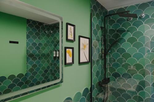 a bathroom with a mirror and a green wall at Apartamento The River in El Puerto de Santa María